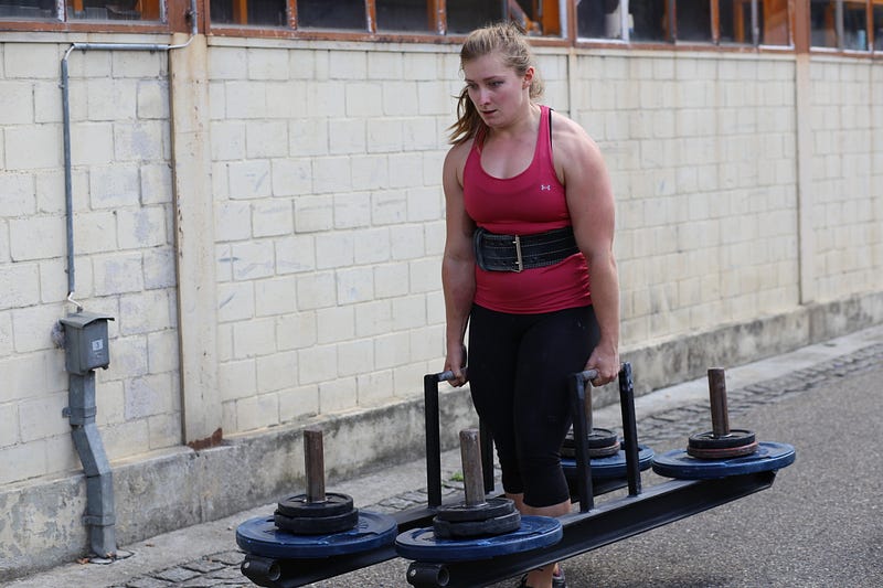 Woman lifting weights in a competitive setting.