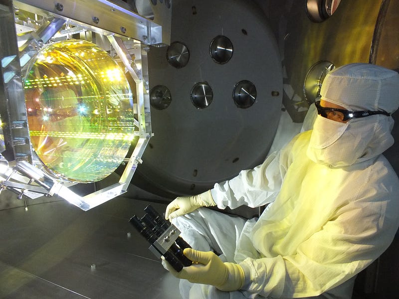 Technician examining LIGO mirrors